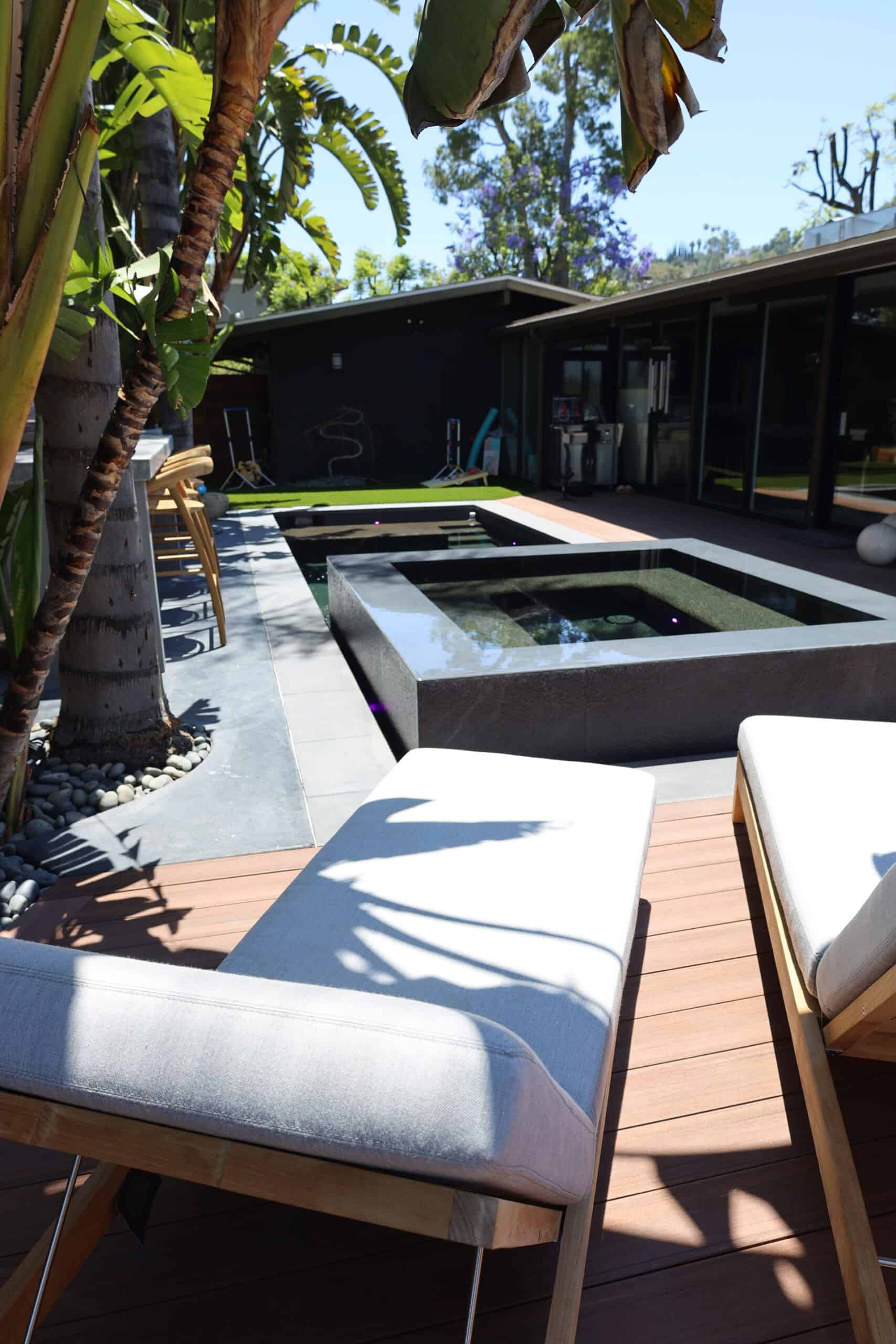 Raised spa spillover beside a mid-century home